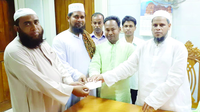 DUPSHANCHIA(Bogura): Belal Hossain, Municipal Mayor handing over cheque to Abdul Latif, superintendent of Miftahul Ulum Hafezia and Nurani Madrash a at Dupchanchia Upazila on Sunday.