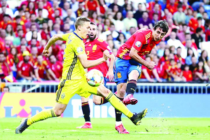 Spain's Mikel Oyarzabal (right) shoots to score his side's third goal during the Euro 2020 Group F qualifying soccer match between Spain and Sweden at the Santiago Bernabeu stadium in Madrid on Monday.