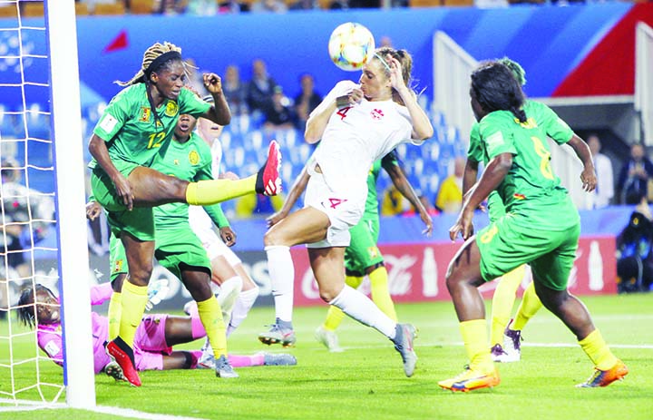 Cameroon's Claudine Meffometou (left) kicks the ball clear of the goal as Canada's Shelina Zadorsky (centre) attempts to block the shotduring the Women's World Cup Group E soccer match between Canada and Cameroon in Montpellier, France on Monda