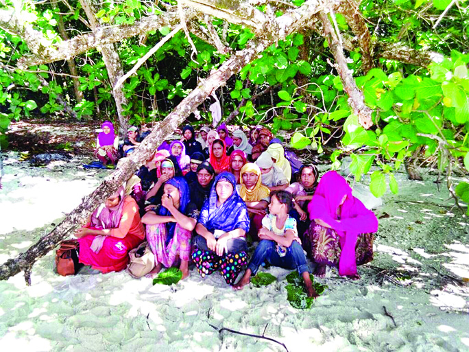 Rohingya women are seen on a beach after a fishing boat carrying more than sixty Rohingya refugees were found beached at Rawi Island, part of Tarutao national park in province of Satun, Thailand, bordering with Malaysia, according to officials on Tuesday.