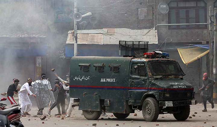 Kashmiri demonstrators attack an Indian police vehicle with pieces of bricks and stones during a protest in Srinagar.