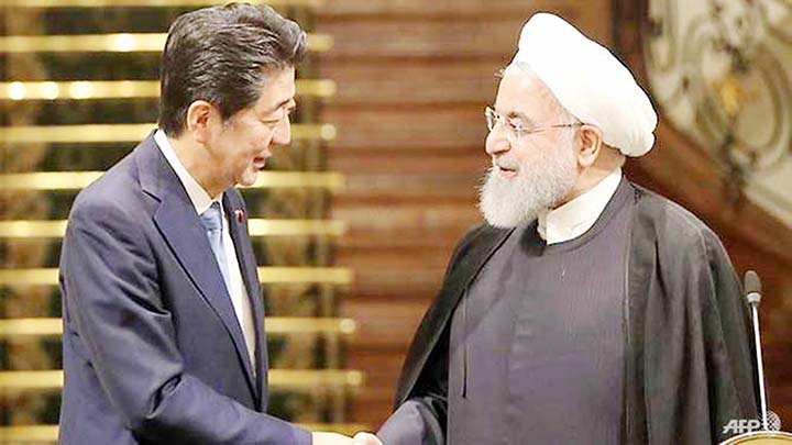 Iranian President Hassan Rouhani shakes hands with Japanese Prime Minister Shinzo Abe (left) at the Saadabad Palace in the capital Tehran.