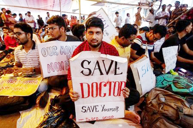 A doctor holds a placard at a government hospital during a strike demanding security after the recent assaults on doctors by the patients' relatives, in Kolkata.