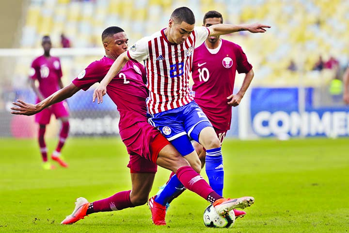 Qatar's Pedro Correia (left) and Paraguay's Miguel Almiron battle for the ball during a Copa America Group B soccer match at the Maracana stadium in Rio de Janeiro, Brazil on Sunday.