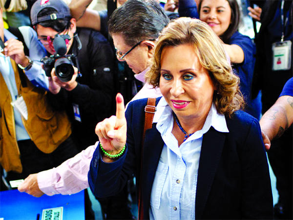 Sandra Torres, former first lady and presidential candidate for the National Unity of Hope (Union Nacional de la Esperanza) party, center, displays an inked finger after voting during presidential elections in Guatemala City, Guatemala.