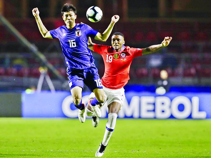 Japan's Takehiro Tomiyasu (left) and Chile's Junior Fernandes fight for the ball during a Copa America Group C soccer match at the Morumbi stadium in Sao Paulo, Brazil on Monday.