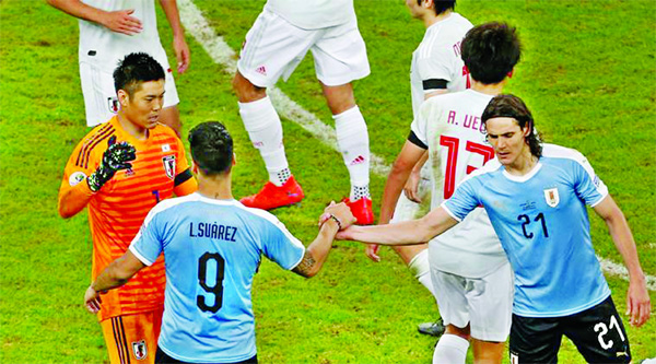 Uruguay's Luis Suarez shakes hands with strike partner Edinson Cavani and Japan goalkeeper Eiji Kawashima after the match of the Copa America between Uruguay and Japan, at Porto Alegre in Brazil on Thursday.
