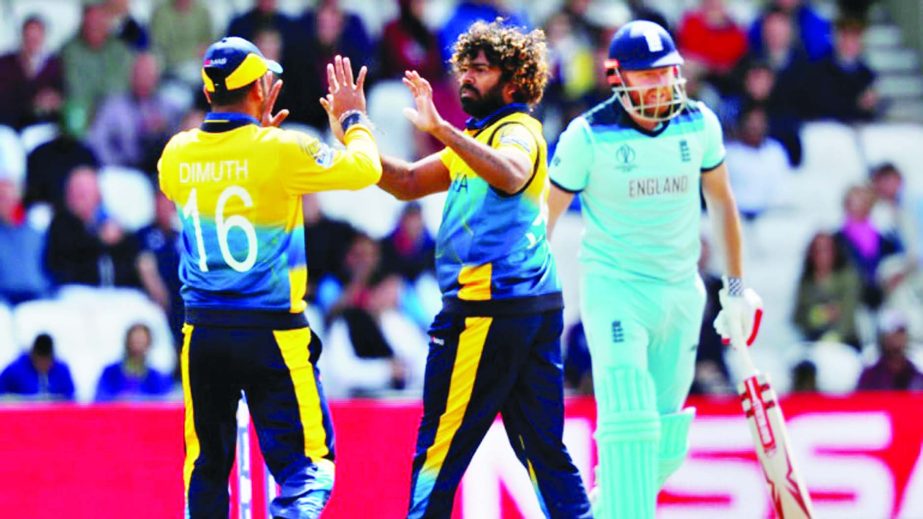 Lasith Malinga (centre) of Sri Lanka celebrates with his teammate Dimuth Karunaratne after dismissal of Jonny Bairstow (extreme right) during the match of the ICC World Cup Cricket between England and Sri Lanka at Leeds in England on Friday. Sri Lanka sco