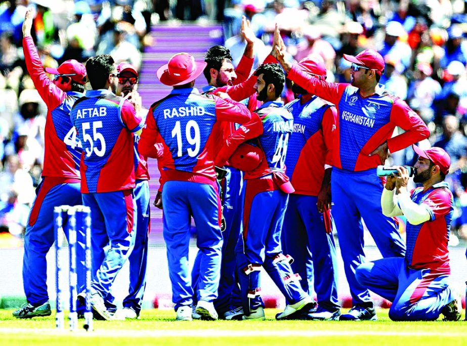 Afghanistan's Rahman Shah (center left without cap) celebrates with teammates the dismissal of India's Vijay Shankar during the ICC World Cup Cricket match between India and Afghanistan at the Hampshire Bowl in Southampton, England on Saturday.