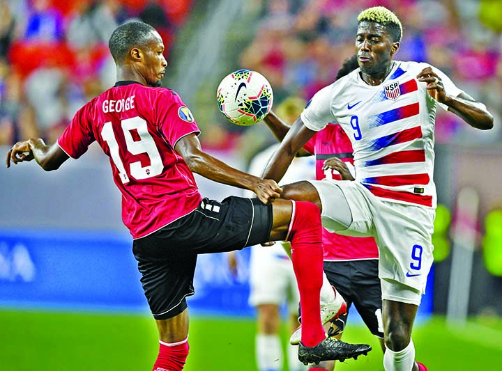 U.S. forward Gyasi Zardes and Trinidad and Tobago midfielder Kevan George (19) go for the ball during the second half of a CONCACAF Gold Cup soccer match in Cleveland on Saturday. The United States won 6-0.
