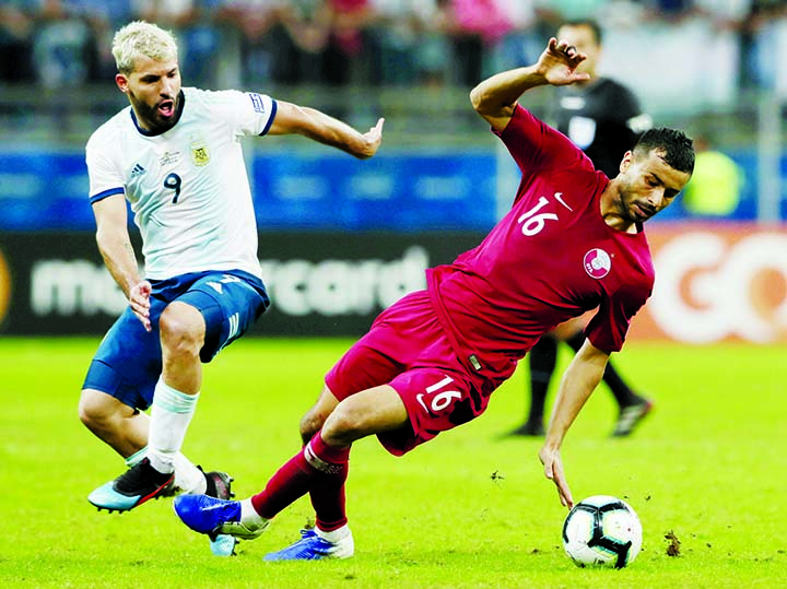 Argentina's Sergio Aguero (left) and Qatar's Boualem Khoukhi battle for the ball during a Copa America Group B soccer match at Arena do Gremio in Porto Alegre, Brazil on Sunday.