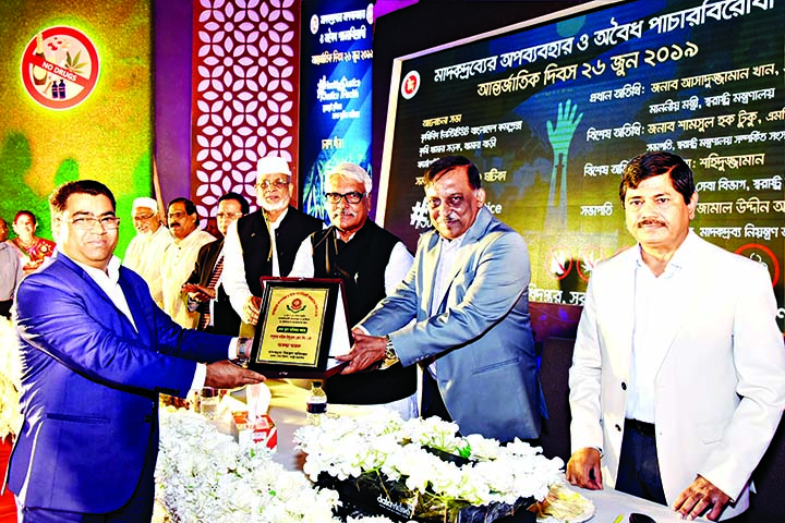 BM Shawkat Ali, Additional Managing Director, Popular Life Insurance Company Ltd receiving crest from Home Minister Asaduzzaman Khan Kamal MP on behalf of the company as first prize for outstanding contributions in anti- drug activities recently. Md Sh