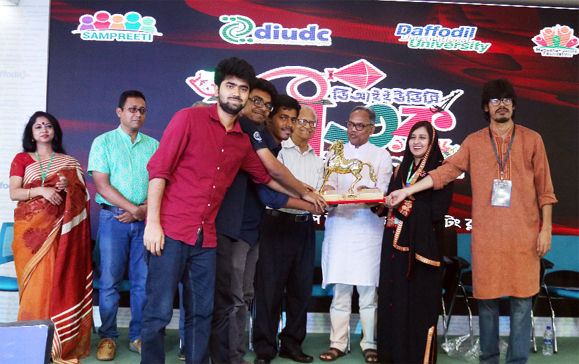Renowned artist Mustafa Monowar and novelist Imdadul Haq Milan handing over the champion trophy of 'DIUDC Bitorko Mohaparbon-1426' to the winning team members of Bangladesh University of Engineering & Technology held on Saturday.