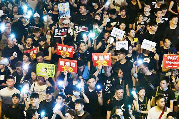 Protesters switch on their phones' flashlights during the annual pro-democracy march in Hong Kong on Monday, the anniversary of its handover to Beijing in 1997.