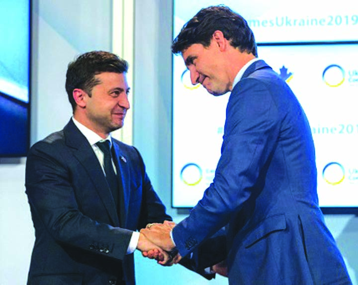 Canadian Prime Minister Justin Trudeau and Ukrainian President Volodymyr Zelensky hold hands after Trudeau's address to the Ukrainian Reform conference in Toronto.