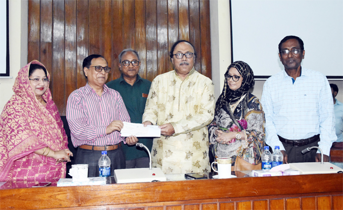 AHM Khairuzzamn Liton, Mayor of Rajshahi City Corporation hands over a cheque to Prof M Abdus Sobhan, Vice Chancellor of Rajshahi University for providing scholarships among the meritorious and underprivileged students of the University in a function at S