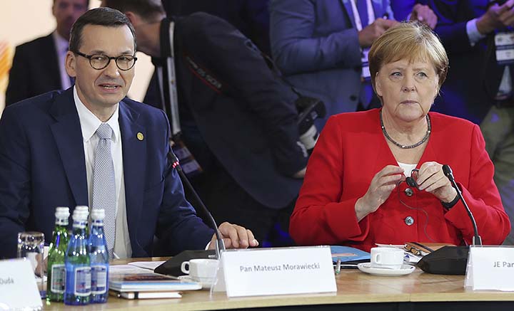 German Chancellor Angela Merkel,right, and Poland's Prime Minister Mateusz Morawiecki listening to a speech by Poland's President Andrzej Duda during a summit meeting that aims to reassure Western Balkan states that their aspirations to join the Europea