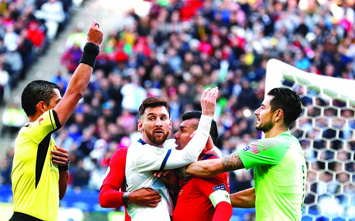 Argentina's Lionel Messi (center left) and Chile's Gary Medel (center right) scuffle as referee Mario Diaz, from Paraguay (left) shows the red card to both of them during Copa America third-place soccer match at the Arena Corinthians in Sao Paulo, Brazi