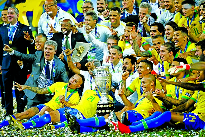 Brazil's team pose with the Championship trophy after defeating Peru 3-1 in the final match of the Copa America at Maracana stadium in Rio de Janeiro, Brazil on Sunday.