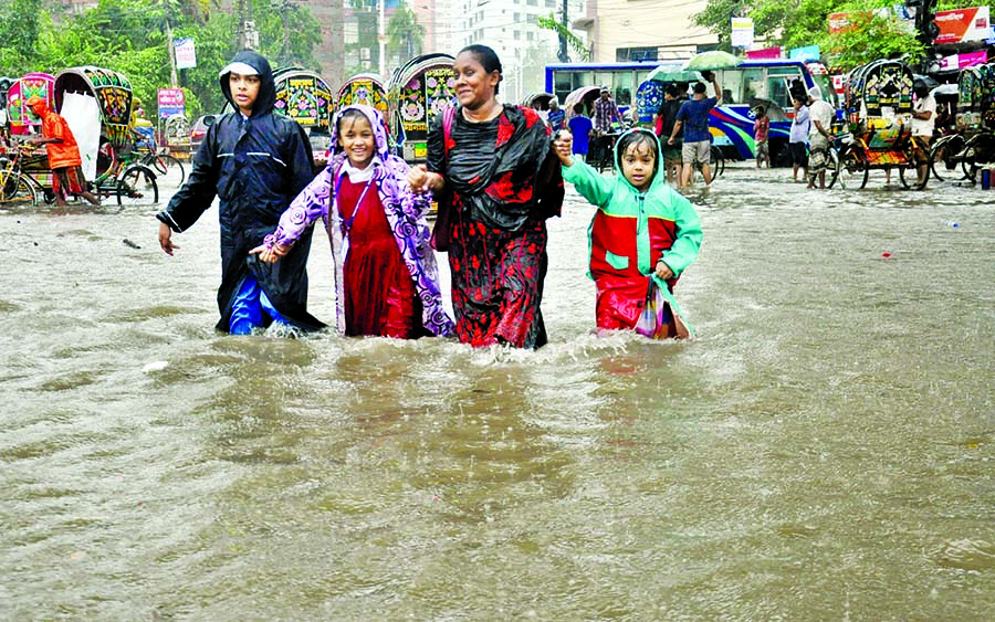 Most of the roads in low-lying areas of Chattogram went under water following incessant rainfalls while students along with their parents are seen going to schools defying knee-deep water. This photo was taken from Sholashahar- No 2 Gate on Monday.