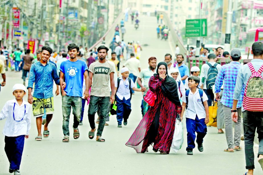 The people of different professions walking by the road due to rickshaw pullers street siege on Tuesday protesting ban on rickshaw on three main streets of the city.