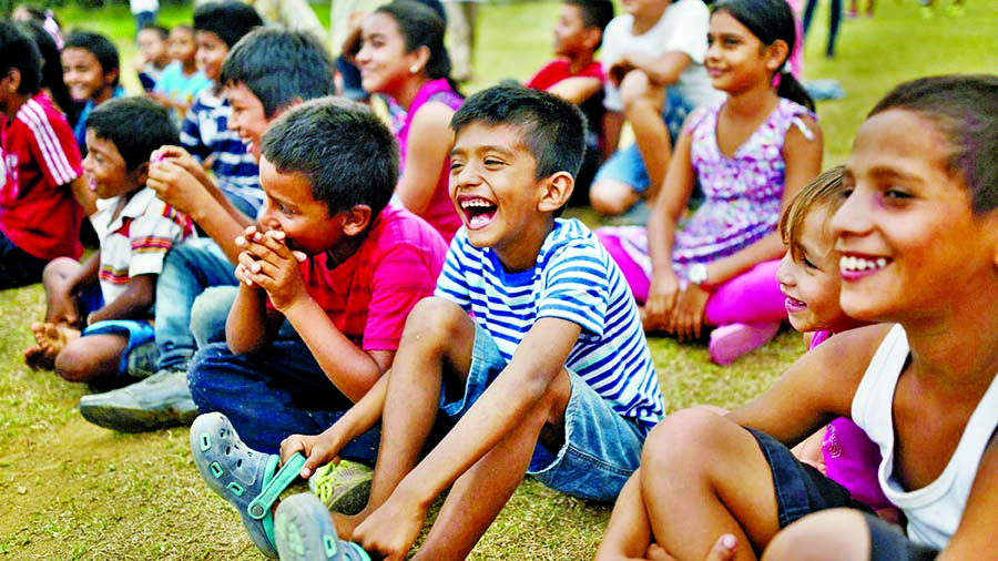 Central American migrant children laugh at a show put on by a clown. Internet photo