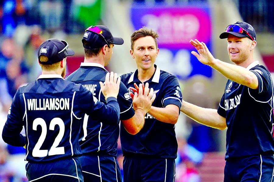 New Zealand's Trent Boult (without cap) celebrates with teammates after dismissing Ravindra Jadeja during the ICC World Cup Cricket semi-final match between New Zealand and India at Old Trafford in Manchester on Wednesday.
