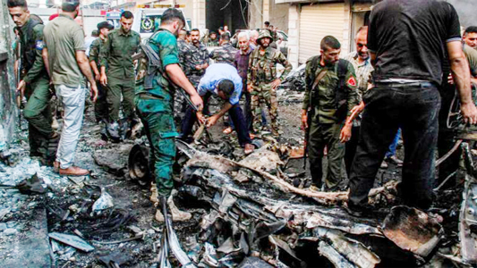 Syrian Kurdish security forces inspect the wreckage of a rigged car which detonated outside the Syriac Orthodox Church of the Virgin Mary in the predominantly Christian neighbourhood of al-Wasti in the Kurdish-majority city of Qamishli in northeast Syria