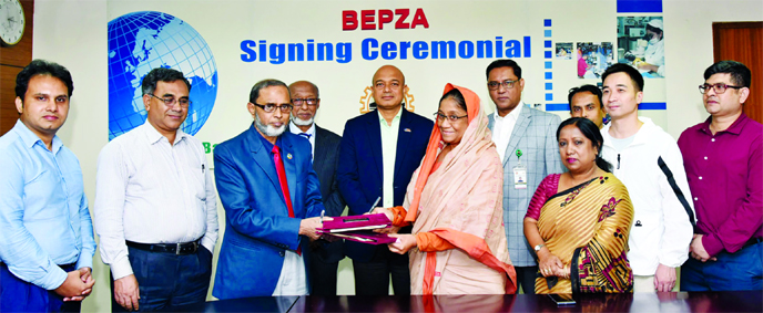 Zillur Rahman, Member (Investment Promotion) of Bangladesh Export Processing Zones Authority (BEPZA) and Amin Nargis, Director of Ms Golden Ocean Ltd, exchanging an agreement signing document at BEPZA complex in the city on Monday.