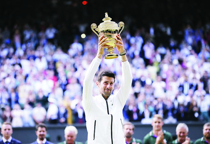 Serbia's Novak Djokovic lifts the trophy after defeating Switzerland's Roger Federer in the men's singles final match of the Wimbledon Tennis Championships in London on Sunday.
