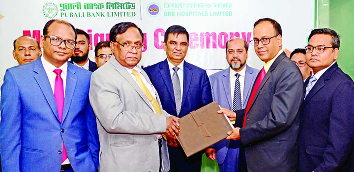 Md Abdul Halim Chowdhury, Managing Director of Pubali Bank Ltd and Major (Retd) AKM Mahbubul Hoque, Chief Executive Officer of BRB Hospitals Ltd, exchanging a Memorandum of Understanding (MoU) signing document at the Bank's head office in the city on Tue