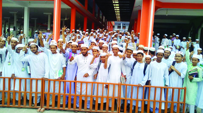 JHALOKHATHI: Students of Jhalokathi Kamil Madrasa showing V-sign after their successful HSC result on Wednesday.