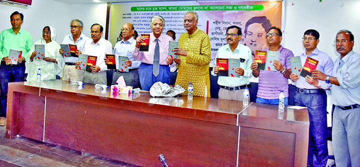 Participants hold the copies of books titled 'Tapashyar Alo' written by Jyotika Rani and 'Beyond Border' written by Sirajul Islam at its cover unwrapping ceremony organised by Amor Prokashoni at the Jatiya Press Club on Wednesday.