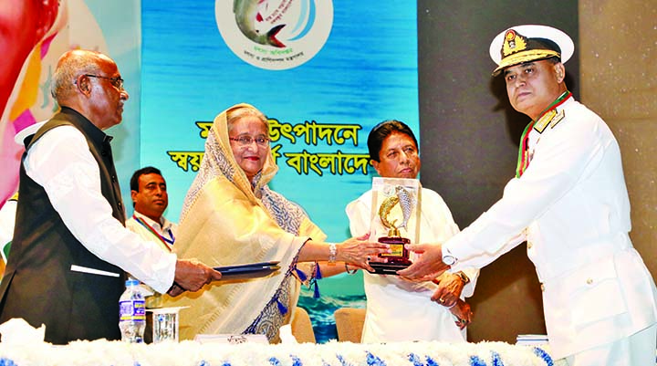Prime Minister Sheikh Hasina handing over National Fishery Award-2019 to the Chief of Naval Staff Admiral Aurangzeb Chowdhury for his contribution for the development of country's fishery resources at a ceremony held in KIB auditorium in the city on Thur