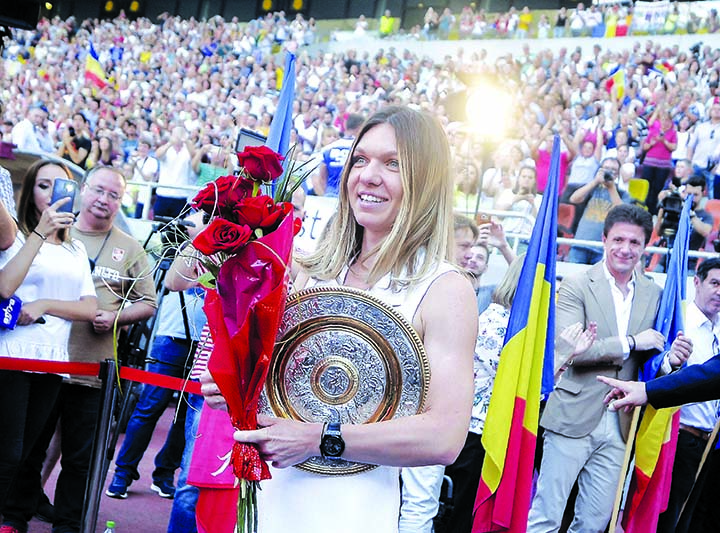 Romania's Simona Halep, winner of the 2019 Wimbledon Tennis Championships, arrives holding a replica of the tournament trophy, at an event, attended by thousands of fans, celebrating her success on the National Arena Stadium in Bucharest, Romania on Wedn