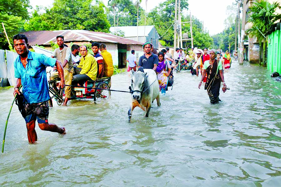 People move along a flooded road in Gaibandha on Thursday.