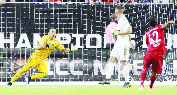 Real Madrid goalkeeper Keylor Navas prepares to dive on the score attempt by FC Bayern forward Sarpreet Singh (42) as Adrian De La Fuente (middle) looks on during the second half of an International Champions Cup soccer match on Saturday.