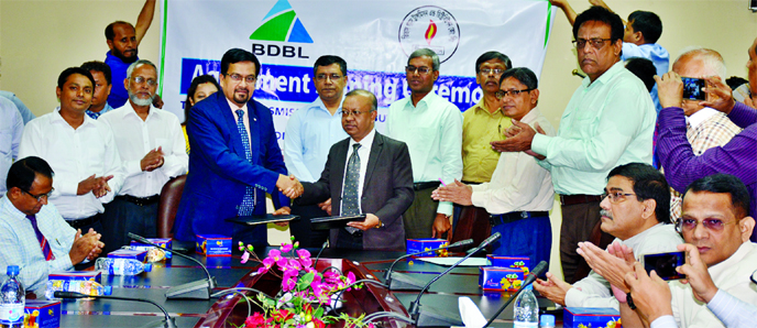 Paritosh Sarker, General Manager of Bangladesh Development Bank Ltd and Mahmudur Rab, Company Secretary of Titas Gas, exchanging an agreement signing document at Titas Gas Head Office at Karwan Bazar in the city on Thursday. Managing Director of Titas Gas