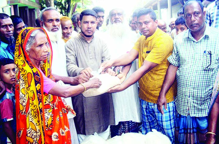 SAGHATA (Gaibandha): Businessman Alhaj Abdul Goni Bablu distributing relief goods among the flood- hit people at Bhangarpara Village on Sunday.