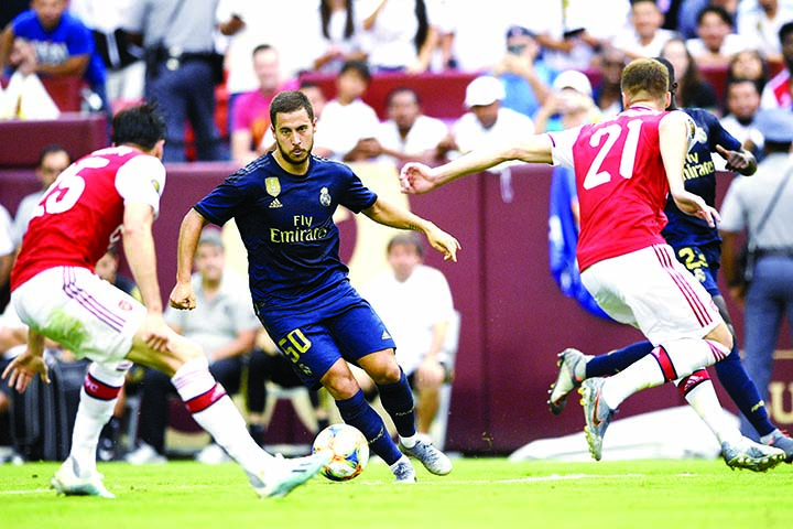 Real Madrid forward Eden Hazard (50) controls the ball against Arsenal defenders Carl Jenkinson (25) and Calum Chambers (21) during the first half of an International Champions Cup soccer match in Landover on Tuesday.