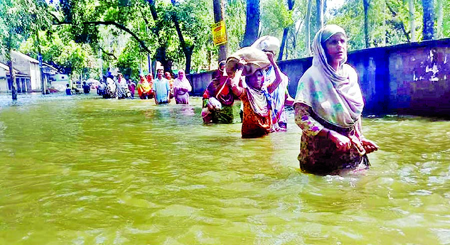 Thousands of people wading through the flood water and going to safer places as the flood situation worsening further. This photo was taken from Chilmari area on Thursday.