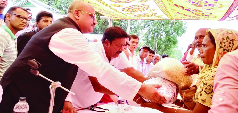 SARISHABARI (Jamalpur): State Minister for Information Dr Murad Hassan along with officials of District Administrations distributing relief materials among the flood affected people at different spots in Sarishabari on Tuesday.