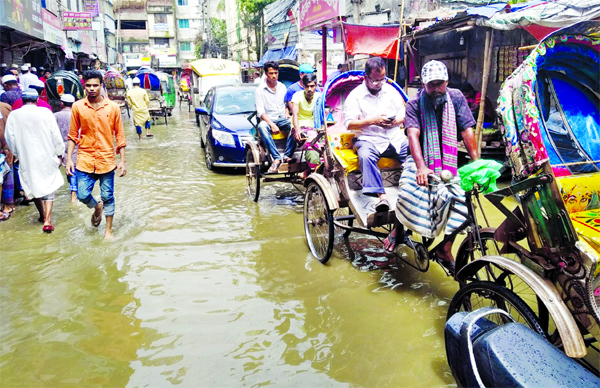Motorised vehicles, rickshaws and also pedestrians struggle through the stagnated rain water due to absence of proper drainage system. The snap was taken from the city's Gigatala on Friday.