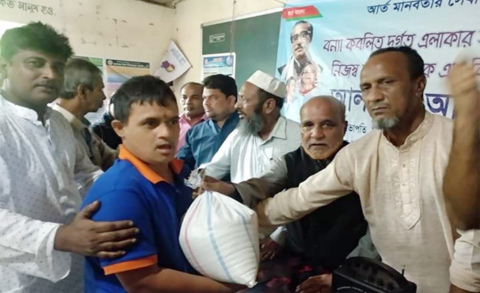 Md Abu Said, Vice- President, Awami League, Dakkhin District Unit of Chattogram distributing relief goods among the flood- hit people at Satkaniya recently.