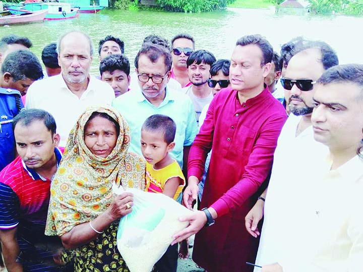 GAFARGAON (Mymensingh): Fahmi Golundaz Babel MP distributing relief goods among the flood hit- people at Gafargaon Islamia Government High School as Chief Guest on Monday.
