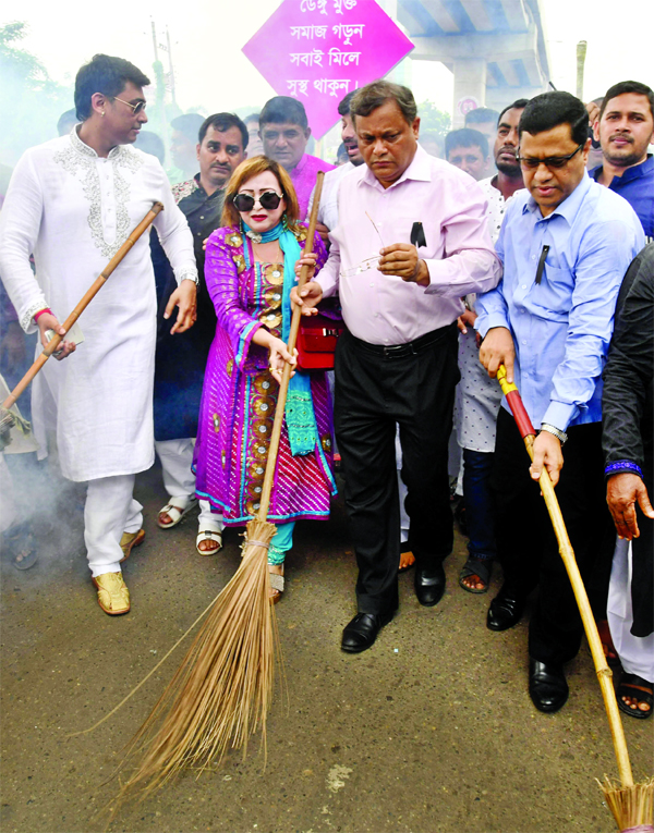 Information Minister Dr. Hasan Mahmud along with others at a clealiness drive on BFDC premises in the city on Friday.