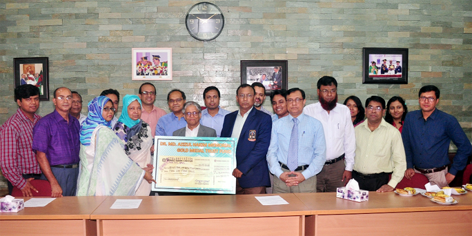 Asuma Begum, wife of late Dr Md. Azizul Hakim hands over a cheque for Tk 10 lac to Prof Dr Md. Kamal Uddin, Treasurer of the Dhaka University at the University Vice-Chancellor's office to introduce a Gold Medal on Wednesday. Vice-Chancellor Prof Dr Md. A