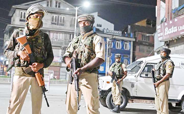 Indian paramilitary troopers stand guard at a roadblock at Maisuma locality in Srinagar.