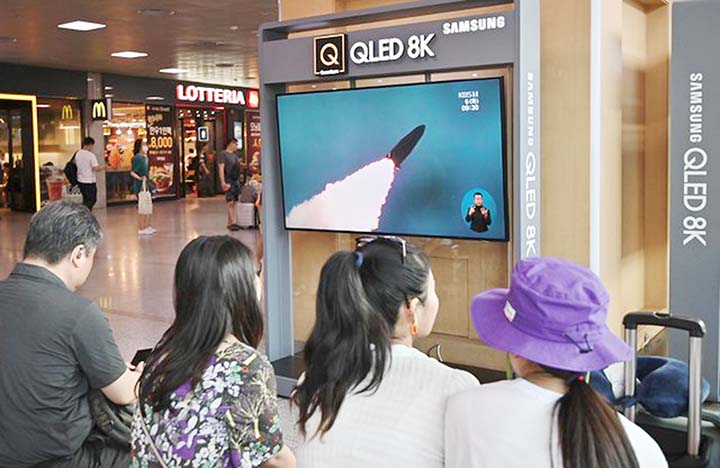 People watch a television news screen showing a file footage of North Korea's missile launch, at a railway station in Seoul on Tuesday.