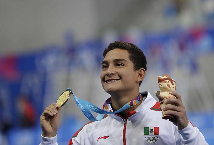 Gold medalist Kevin Berlin of Mexico poses for photos with his gold medal at the podium for the men's diving 10m platform final at the Pan American Games in Lima, Peru on Monday.